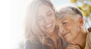 photo of senior woman and younger woman hugging